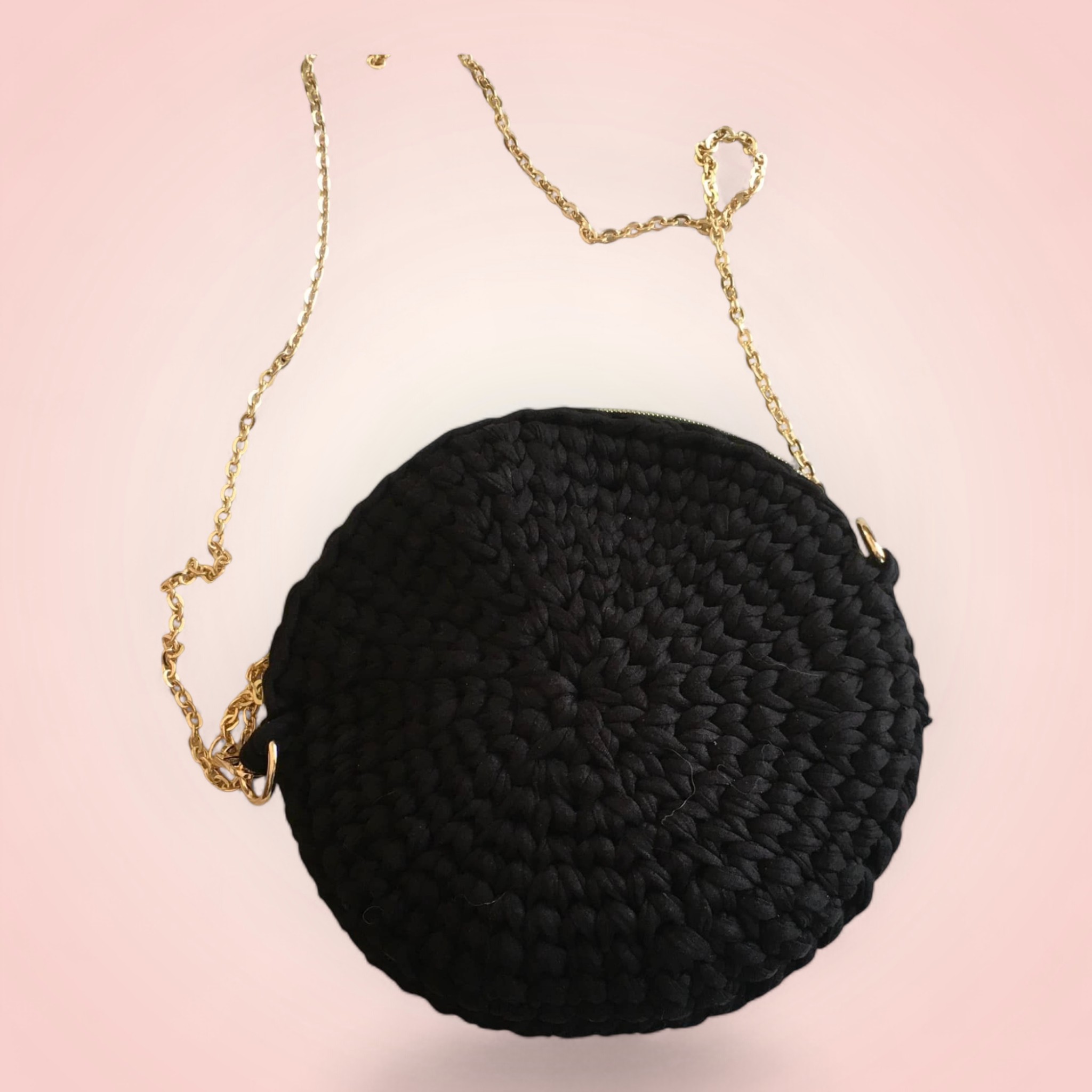 Sac à Main Rond Noir - Originalité et Élégance 1 Sac à main noir rond avec chaîne dorée.