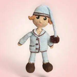 Adorable peluche Dormeur en crochet, vêtue d'un pyjama et d'un bonnet de nuit.