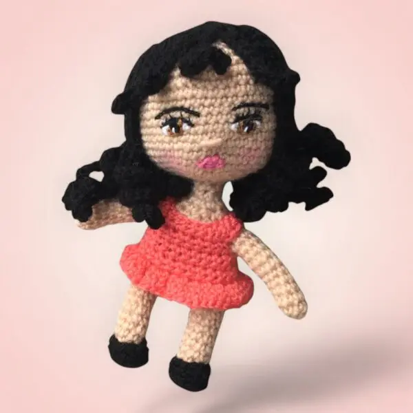 Charmante poupée au crochet avec une robe saumon.