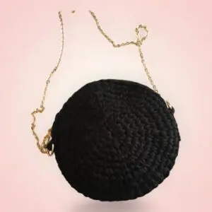Sac à main noir rond avec chaîne dorée.