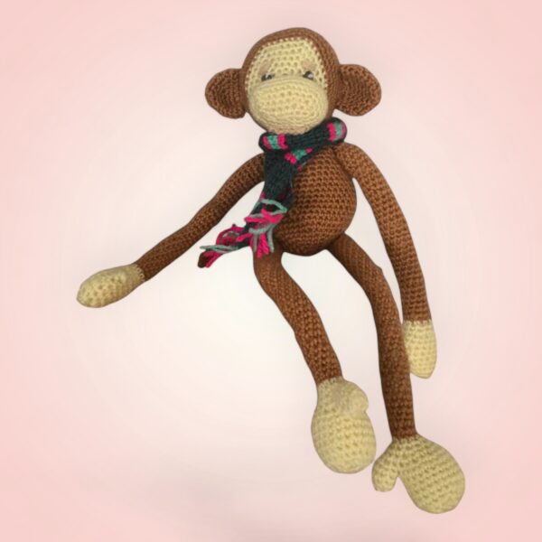 Singe en crochet avec une écharpe colorée.
