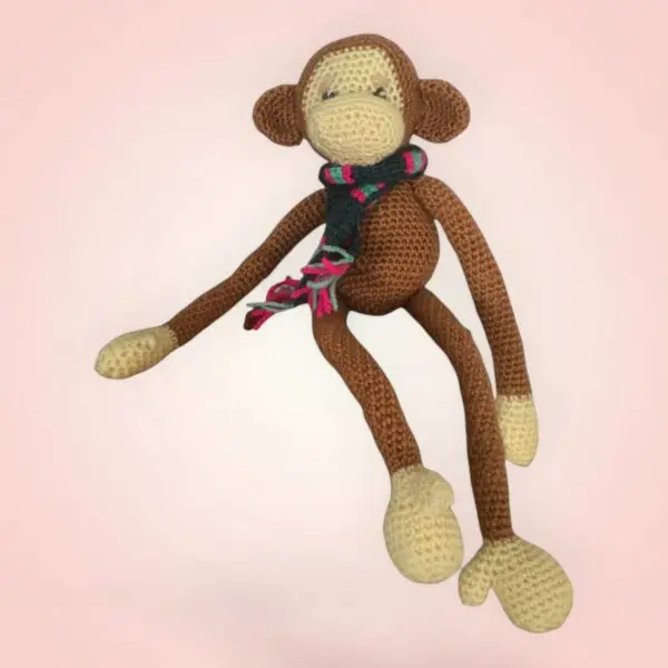 Singe en crochet avec une écharpe colorée.